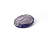 a close up of a purple gemstone on a white surface