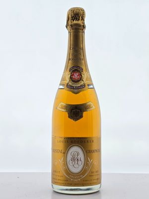 une bouteille de champagne posée sur une table près d'un mur blanc