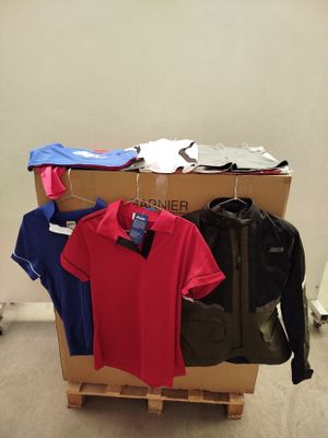 un tas de vêtements posé sur une palette dans une pièce