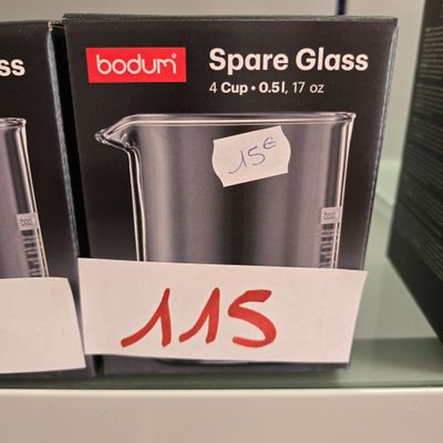 two boxes of glass measuring cups on a shelf in a store