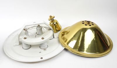 a close up of a white and gold lamp on a white surface