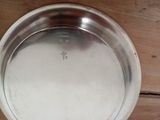 a silver plate on a wooden table with a brown table cloth