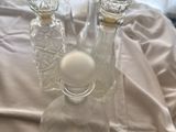 three glass vases sitting on a table with a white cloth
