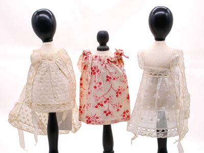 trois mannequins vêtus de robes, exposés