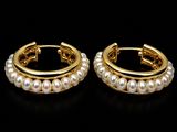 une paire de boucles d'oreilles créoles en perles sur fond noir