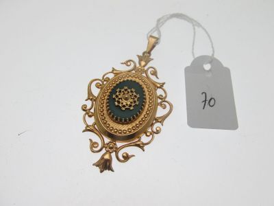 une photo d'un collier doré et vert muni d'une étiquette