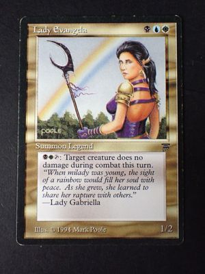 a close up of a card with a picture of a woman holding a scythe