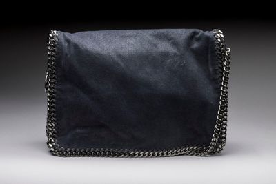 a small black bag with a chain strap on a grey background