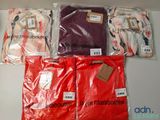 four bags of clothing on a table with tags on them