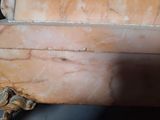a piece of marble on the floor next to a pile of coins