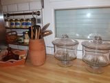three jars on the counter with utensils in them