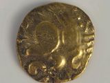 a close up of a gold coin on a white surface