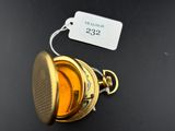 a small gold object on a black surface with a price tag attached to it
