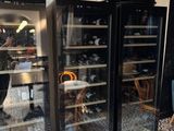bottles of wine are in the fridges in a restaurant