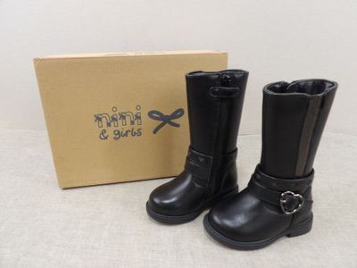 deux paires de bottes en cuir noir à boucles et une boîte à l'arrière-plan