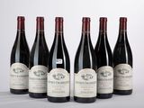 six bouteilles de vin sont alignées sur une table