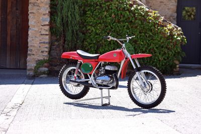 a red dirt bike parked in front of a stone building