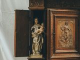 a wooden cabinet with a statue on top of it