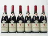 six bouteilles de vin sont alignées sur une table