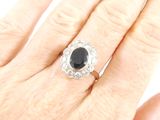 an image of a woman ' s hand holding a black and white diamond ring