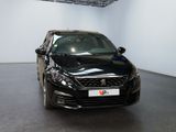 the black car is parked in the large room of the showroom