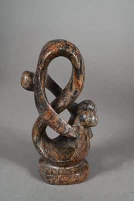 two wooden sculptures of a snake and a snake on a table