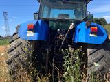 un tracteur bleu garé dans un champ
