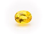 a yellow sapphire stone on a white background