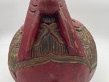 an image of a red and gold bell sitting on top of a white surface