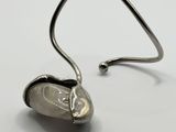 a close up of a metal hook with a heart shaped object on it