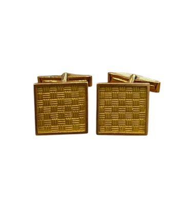 a close up of a pair of gold cufflinks on a white background