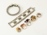 several different rings and bracelets on a white surface