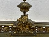 brass plate with a bird on top of it sitting on a shelf