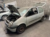 une petite voiture dont le capot est ouvert et qui est garée dans un garage