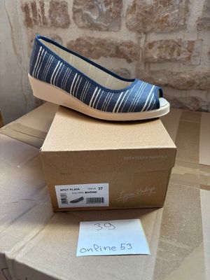blue and white striped shoes on a cardboard box on a table