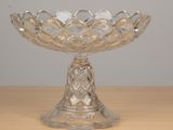 a glass bowl on a table that has a candle inside of it