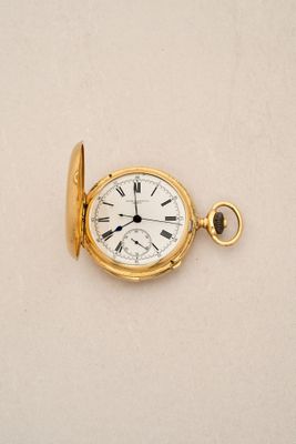 a gold pocket watch with roman numerals on it