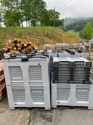 plusieurs caisses en bois empilées les unes sur les autres près d'un tas de bûches