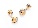 a pair of gold and silver cufflinks on a white background