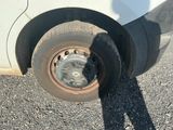 a flat tire on the side of a white van