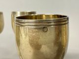 two silver cups sitting next to each other on a table