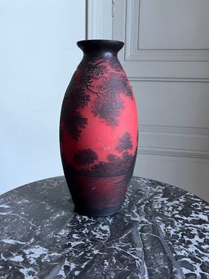 un vase noir et rouge posé sur une table en marbre