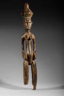 une statue en bois d'un homme avec un chapeau sur la tête