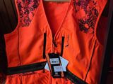 un gilet orange auquel est accroché un téléphone portable, posé sur une chaise