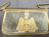une image représentant une bourse en or et en argent ornée d'un aigle
