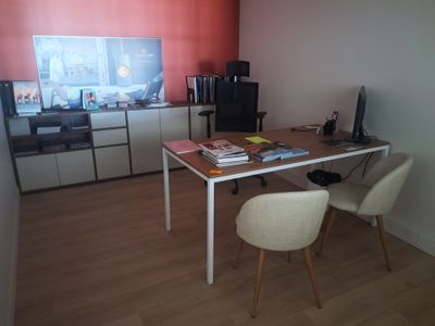 un bureau avec deux chaises et un ordinateur dessus