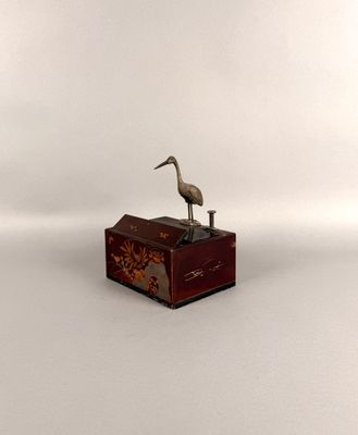 une petite boîte en bois sur laquelle est posé un oiseau