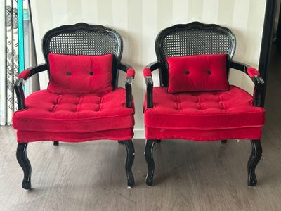 deux chaises rouges aux pieds noirs, sur lesquelles est posé un coussin rouge