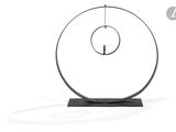 une image représentant une sculpture d'un objet circulaire posé sur un socle