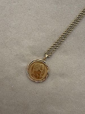 a close up of a coin on a chain on a table